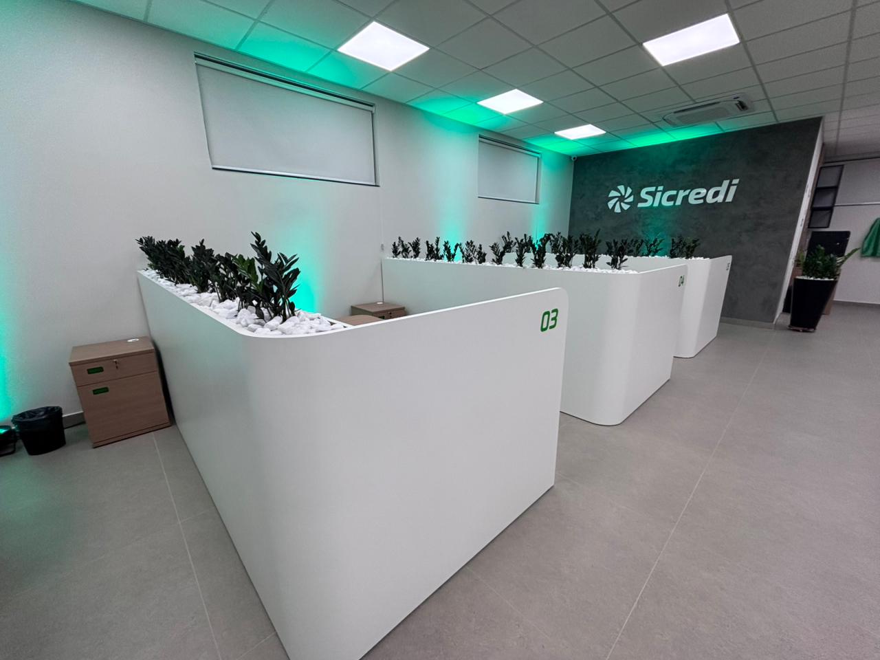 Interior de agência bancária com guichês e identidade Sicredi