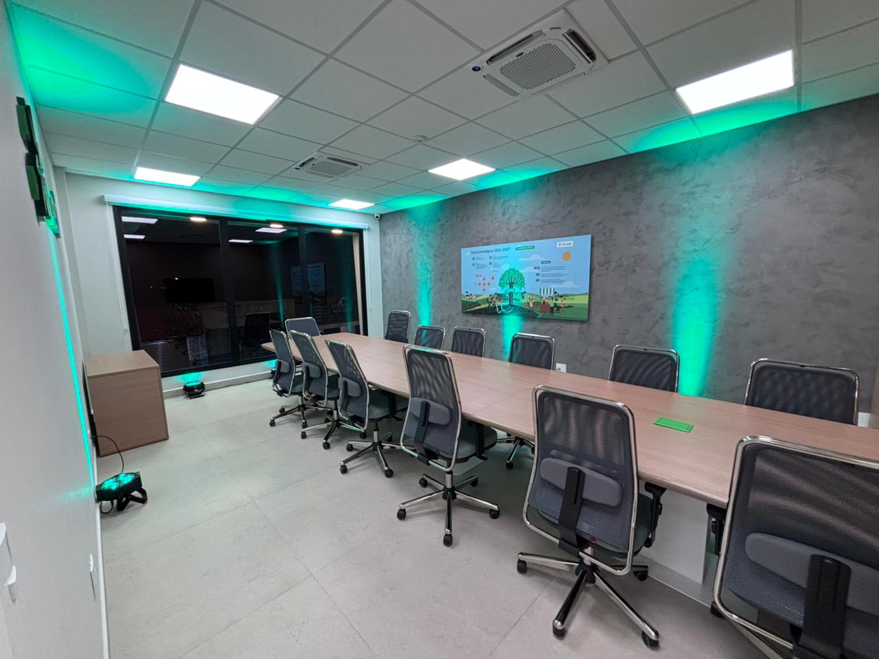 Sala de reunião ampla com painel digital na agência bancária