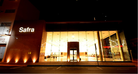 Fachada iluminada da agência Safra à noite