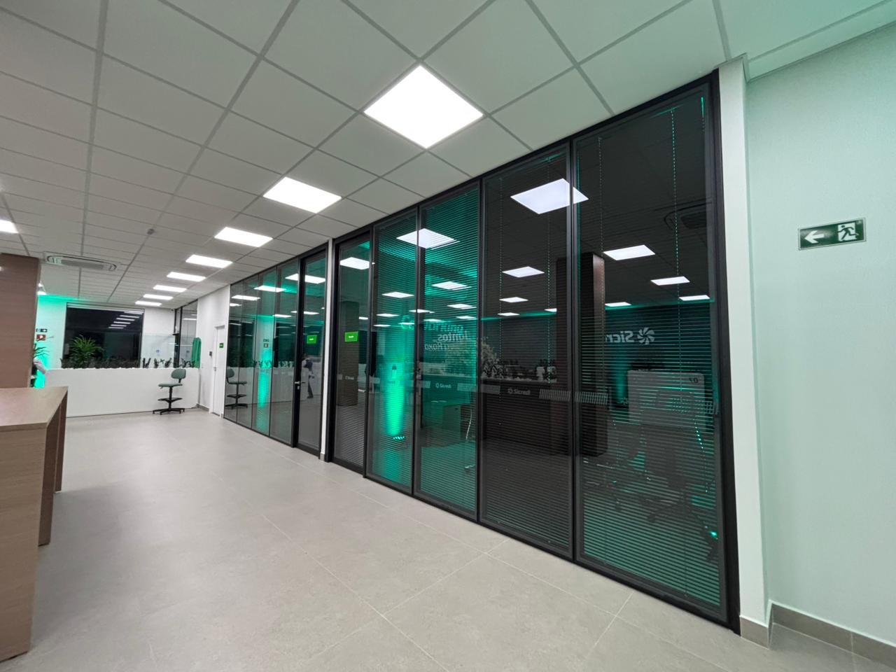 Corredor interno com divisórias de vidro da agência bancária